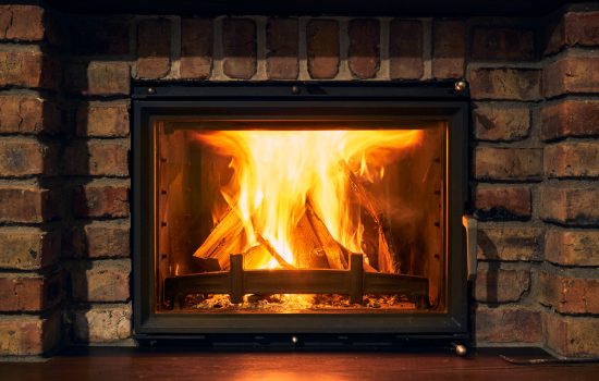 fireplace and fire close view as object or background, brick wall